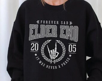 May include: Black sweatshirt with a white graphic print that says "Forever Sad Elder Emo 20 05 It Was Never A Phase". The graphic also includes a skeleton hand making a rock and roll sign.