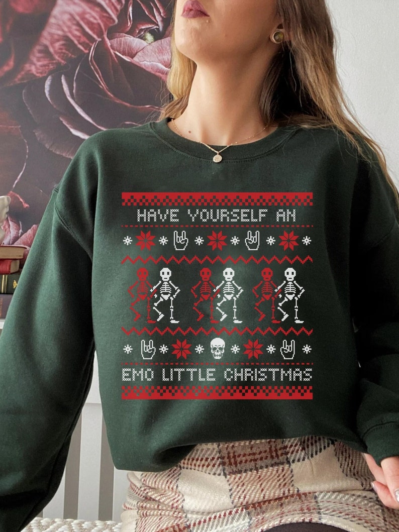 K&ouml;nnte beinhalten: Gr&uuml;ner Weihnachtspullover mit einem rot-wei&szlig;en Muster mit Skeletten, Schneeflocken und dem Text "Have Yourself an Emo Little Christmas".