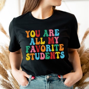 May include: A black t-shirt with a colourful graphic that says "You are all my favourite students".