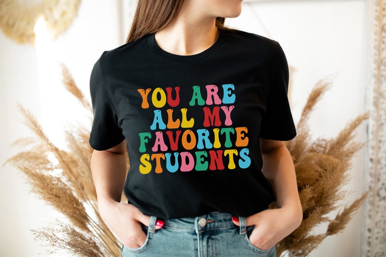 May include: A black t-shirt with a colourful graphic that says "You are all my favourite students".