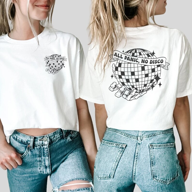 May include: Two white crop tops with a black and white graphic of a disco ball being held by a skeleton hand. The text on the shirt reads "All Panic, No Disco".