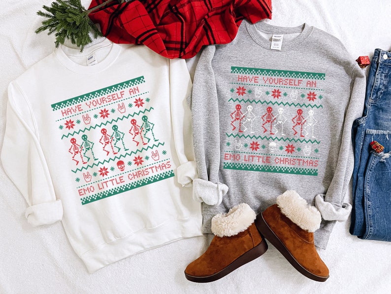 K&ouml;nnte beinhalten: Zwei wei&szlig;e und graue Sweatshirts mit einem Weihnachtsmotiv mit Skeletten und dem Text "Have Yourself an Emo Little Christmas".