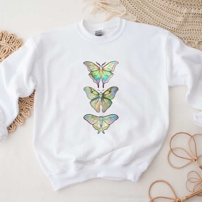 May include: White sweatshirt with a design of three iridescent butterflies in a vertical row.