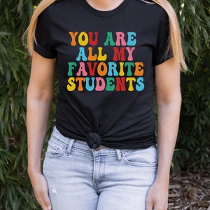 May include: Black t-shirt with the text "You are all my favourite students" in rainbow colours.