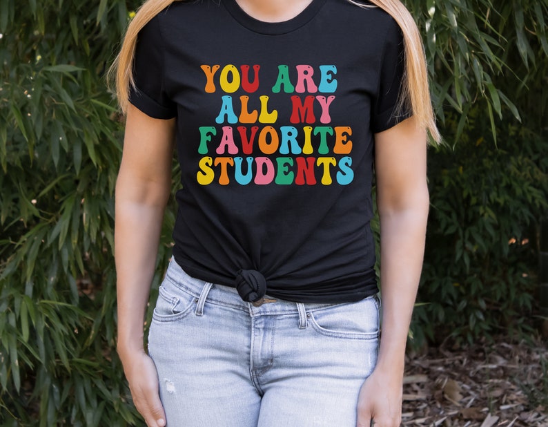 May include: Black t-shirt with the text "You are all my favourite students" in rainbow colours.