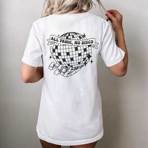 May include: White t-shirt with a black and white graphic of a disco ball being held by a skeleton hand. The text "ALL PANIC, NO DISCO" is on a banner above the disco ball.