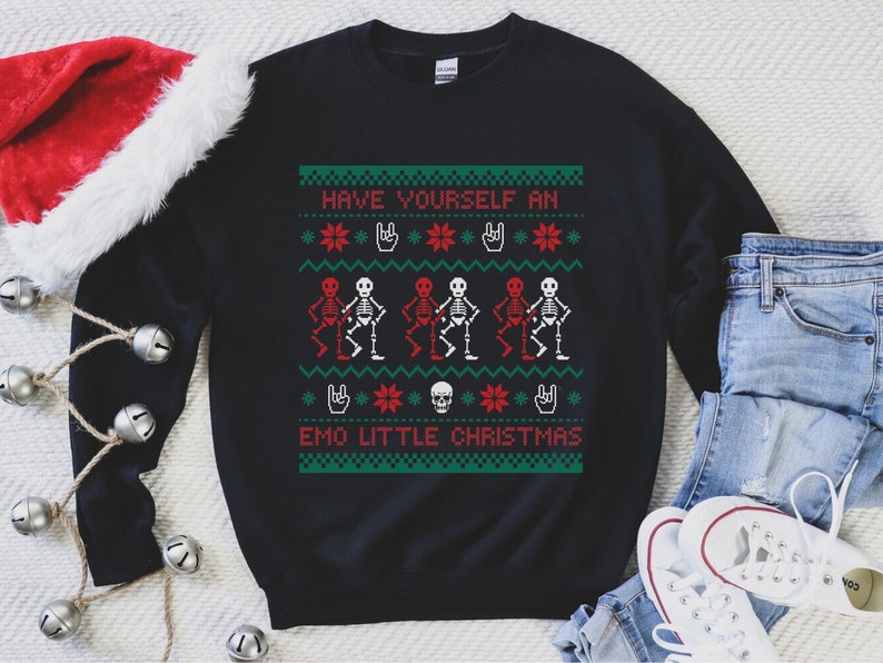 K&ouml;nnte beinhalten: Schwarzer Weihnachtspullover mit gr&uuml;nem, rotem und wei&szlig;em Design. Der Pullover zeigt einen Totenkopf, Sterne und Skelette, die Gitarre spielen. Der Text auf dem Pullover lautet "Have Yourself an Emo Little Christmas".