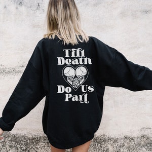 May include: Black sweatshirt with a white graphic print of two skulls in a heart with the text "Till Death Do Us Part".