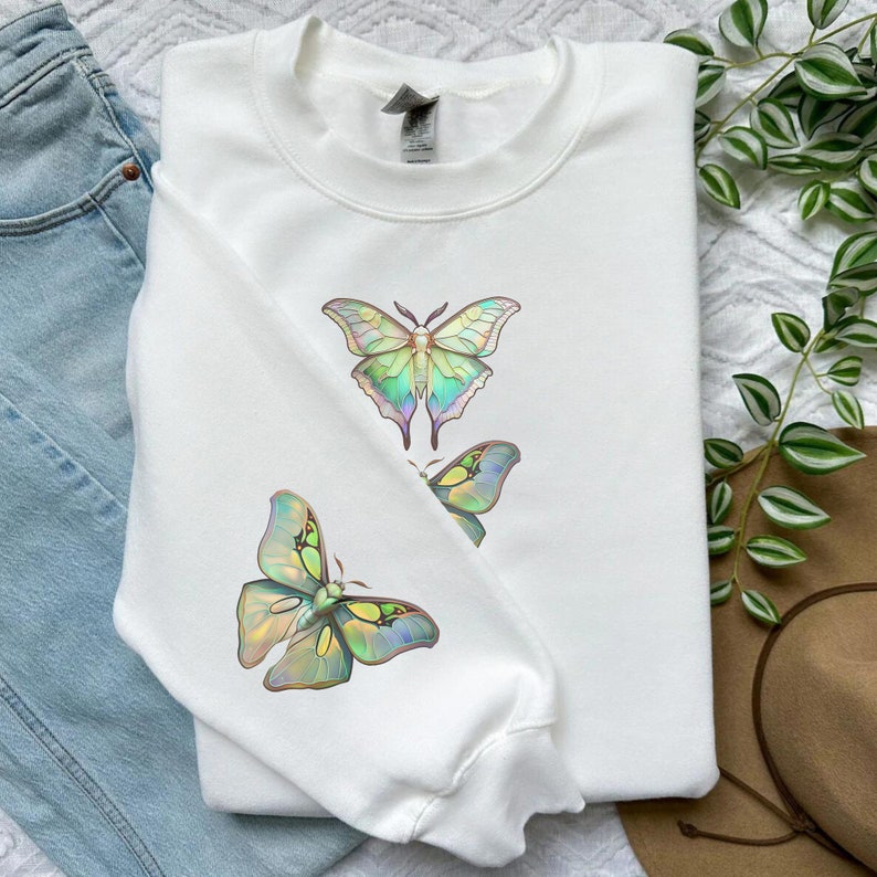 May include: White sweatshirt with a graphic of three iridescent green and blue butterflies.
