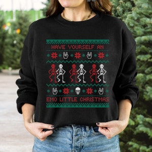 K&ouml;nnte beinhalten: Schwarzer Pullover mit einem weihnachtlichen Design mit Skeletten in Rot und Wei&szlig;, die tanzen, mit dem Text "Have Yourself an Emo Little Christmas".