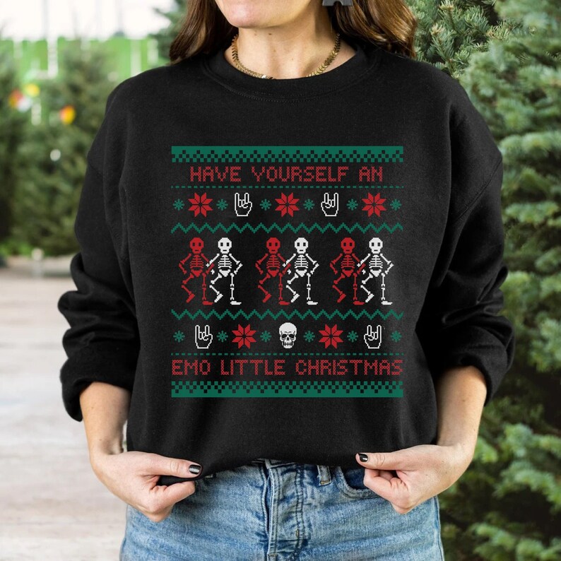 K&ouml;nnte beinhalten: Schwarzer Pullover mit einem weihnachtlichen Design mit Skeletten in Rot und Wei&szlig;, die tanzen, mit dem Text "Have Yourself an Emo Little Christmas".