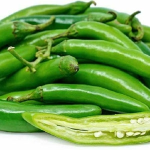 May include: A pile of fresh green serrano peppers, some of which are sliced open to reveal the seeds inside.