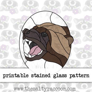 May include: Printable stained glass pattern of a brown and white wolverine with its mouth open, showing its teeth. The wolverine is in an oval frame.