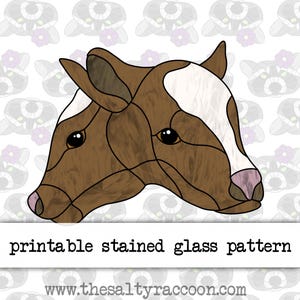 Peut inclure: Patron de vitrail imprimable d'une tête de vache brune et blanche avec un design détaillé. Le patron est parfait pour créer un projet de vitrail unique.