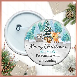 May include: A white button featuring a winter scene with a deer, raccoon, and squirrel in a snowy forest with a Christmas tree. The text "Merry Christmas" is written in a festive font with a line underneath. The text "Personalise with any wording" is written below the line.