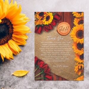 May include: A rustic thank you card with sunflowers and red roses. The card has a wooden background and a burlap overlay. The text on the card reads "Thank You" and "We sincerely thank you for your company, gift good wishes and for helping to make this day an occasion we will always remember. Thank you for joining us as we begin our new life together. Your generosity and thoughtfulness are very much appreciated. Love Scott & Hannah."
