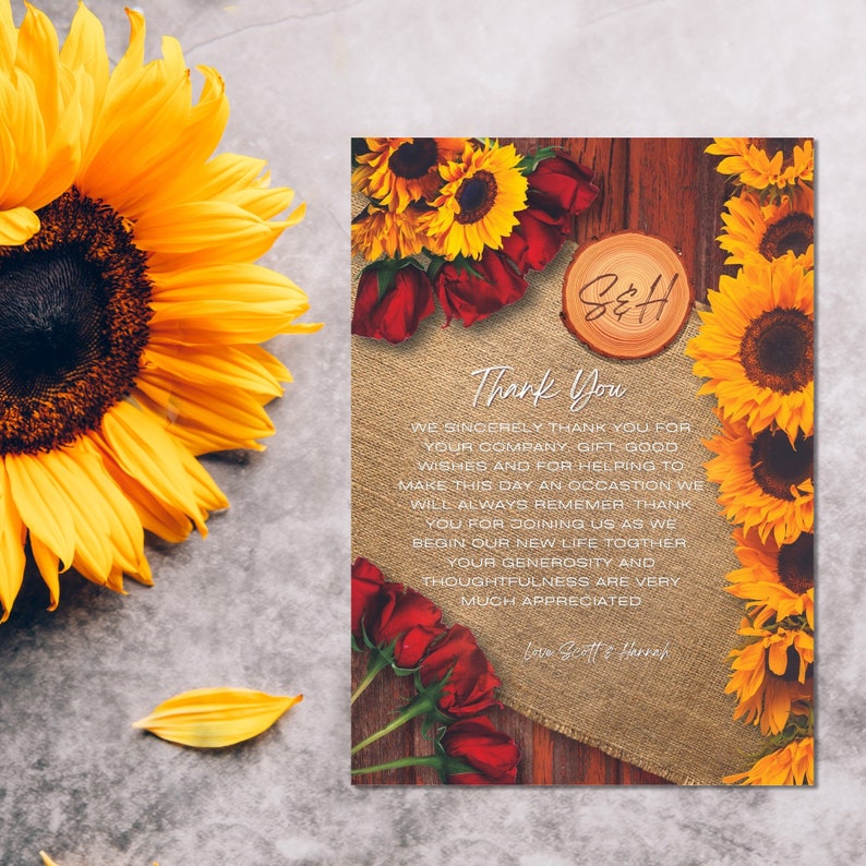 May include: A rustic thank you card with sunflowers and red roses. The card has a wooden background and a burlap overlay. The text on the card reads "Thank You" and "We sincerely thank you for your company, gift good wishes and for helping to make this day an occasion we will always remember. Thank you for joining us as we begin our new life together. Your generosity and thoughtfulness are very much appreciated. Love Scott & Hannah."