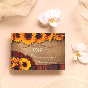 May include: Rustic wedding RSVP card with a burlap background and sunflowers and red roses. The text reads "please reply by June 10th, 20xx RSVP". There are checkboxes for "Accepts with Pleasure", "Number Attending", and "Declines Regretfully".