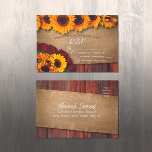 May include: Rustic wedding RSVP card with sunflowers and burlap. The card has a wooden background and the text "Please reply by June 10th, 20xx RSVP Accepts with Pleasure Number Attending Declines Regretfully". The bottom of the card has the text "Hannah James 123 your street. South Any Town. Any State 12345 Place Postcard Stamp Here".