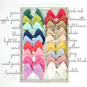 May include: A collection of 16 fabric hair bows in a variety of colors, including green, apple green, mint, blue, light blue, coral, pink, sweet pink, lavender, pink red, terracotta, light brown, khaki, beige, yellow, gray, pink blush, and white.
