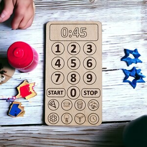 May include: A wooden timer with a digital display showing 0:45. The timer has a number pad with numbers 1 through 9, a start button, a stop button, and a zero button. The timer also has icons for pizza, coffee, popcorn, broccoli, a gear, a light bulb, a propeller, and a clock.