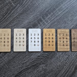 May include: Six wooden timer cards with a white background and black numbers. Each card has the text "0:45" at the top and numbers 1 through 9 in a grid pattern. The cards are arranged in a row from left to right.