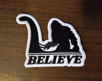 Bigfoot Rides Nessie – 3.5" Iron‑On Cryptid Patch for Hats, Jackets & Backpacks