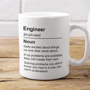 May include: White ceramic mug with a black and white design. The mug features the word "Engineer" with the definition: "Gets excited about things no one else cares about. If no problems are available they will create their own. Solving problems you didn't know you had in a way you can't understand."