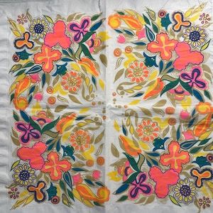 May include: A white paper napkin with a colorful floral pattern. The design features pink, orange, yellow, green, and blue flowers with a white background.