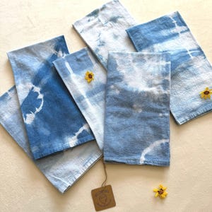 May include: Six blue and white tie-dye kitchen towels with a brown tag that says "Salt & Cedar" and "Hand-dyed and Made in the USA".