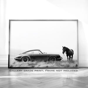 May include: Black and white photograph of a classic black Porsche 911 driving past a black horse in a field.  "GALLERY GRADE PRINT. FRAME NOT INCLUDED." is printed at the bottom of the image.