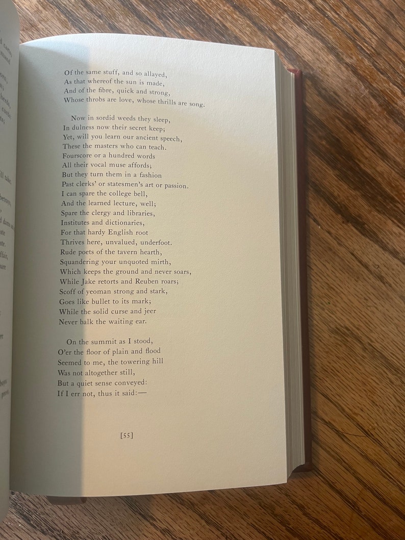 May include: A close-up of a book page featuring a poem printed on it. The poem explores the beauty of nature and the simple pleasures of life. The text is in a classic font and is easy to read. The page is cream-coloured and has a slightly textured surface.