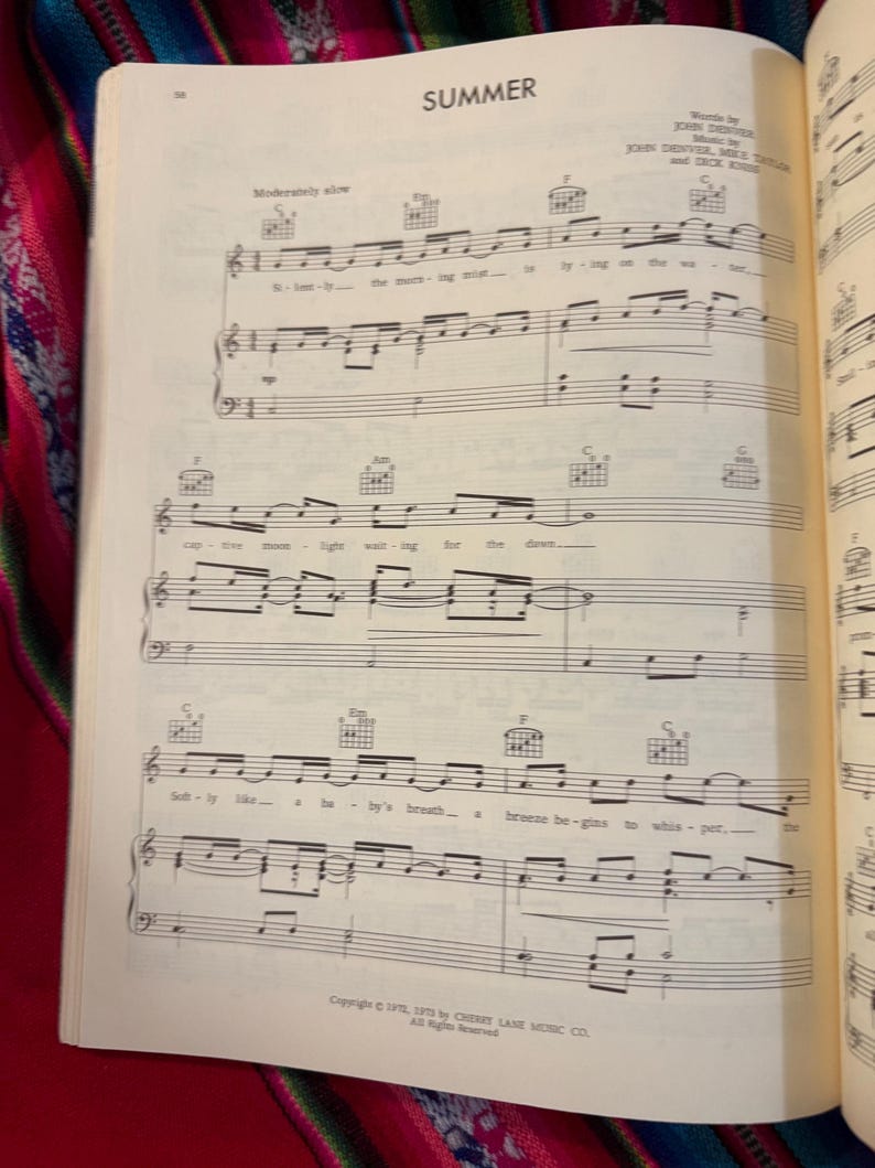 May include: Open book with sheet music for the song "Summer." The title is at the top of the page. The music is written in black ink on cream-colored paper. The page is open to a double-page spread.