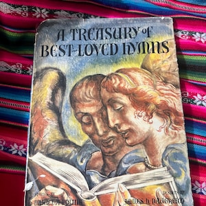 May include: A vintage book titled "A Treasury of Best-Loved Hymns" with a colorful illustration of two people reading a book. The book cover features a blue background with white text and a colorful illustration of two people reading a book.