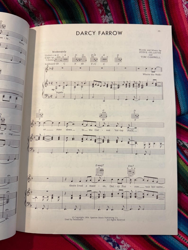 May include: Open book with sheet music for the song "Darcy Farrow." The title is at the top, with the names of the songwriters below. The music includes guitar chords and piano notes. The page is from Sparrow Music Publishing Co.