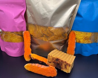 May include: Three resealable bags filled with turmeric root, one pink, one gold, and one blue. A bar of turmeric soap is in the centre of the image.
