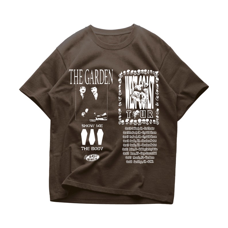 May include: A brown t-shirt with a white graphic print of a band called "The Garden" with the text "West Coast Tour" and a list of tour dates. The graphic also includes the text "Show Me The Body" and a logo for "Deli Records".
