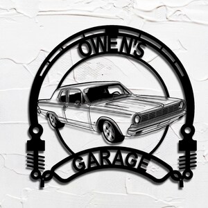 May include: Black metal garage sign with a vintage car design. The sign says "OWEN'S GARAGE" in a decorative font, with a circular frame around the car. The design includes decorative elements on the sides, suitable for a garage.