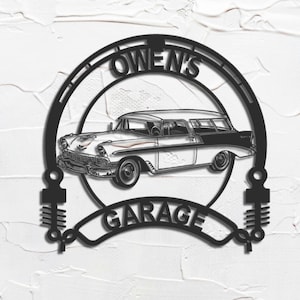 May include: Black metal sign with the words "Owen's Garage" and a classic station wagon silhouette. The sign is circular with decorative elements and is mounted on a textured white surface.