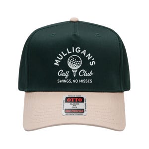 May include: A dark green and tan baseball cap with the text "Mulligan's Golf Club" and a golf ball graphic. The hat has a curved brim and a tag that reads "Classic Fit OSFM Mid Profile Maximum Comfort".