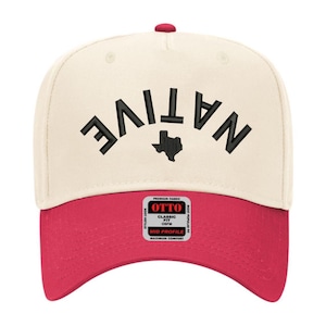 Może przedstawiać: Kremowa czapka bejsbolowa z czerwonym daszkiem. Na przodzie czapki czarnymi literami wygięto słowo "NATIVE", z czarnym konturem Teksasu pośrodku. Czapka ma czerwony guzik na górze i etykietę "OTTO".