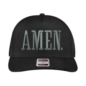 May include: Black baseball cap with the word "AMEN" in a light gray, 3D-style font across the front. The cap has a curved brim and a mesh back for breathability. The Otto Performance logo is on the front.