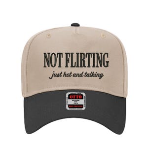 Może przedstawiać: Beżowa i czarna czapka z daszkiem z napisem "NOT FLIRTING just hot and talking" w kolorze czarnym. Czapka ma zakrzywiony daszek i małą metkę z przodu.