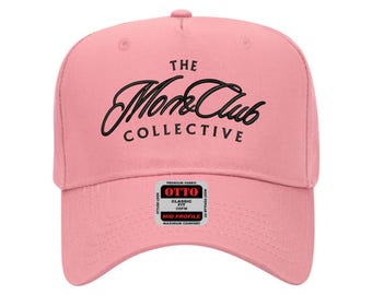 Peut inclure: Casquette de baseball rose clair avec l'inscription "THE Monk&Club COLLECTIVE" en script noir. La casquette a une visière incurvée et une petite étiquette avec du texte supplémentaire. Coupe classique et profil moyen.
