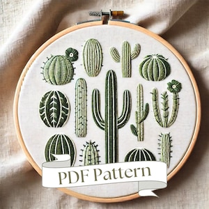 Può includere: Un cerchio da ricamo in legno con uno sfondo in tessuto bianco che presenta una varietà di cactus e piante grasse ricamate in verde. Il cerchio ha una cornice in legno marrone e il testo "PDF Pattern" è scritto su uno stendardo bianco.