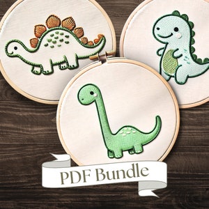 Pode incluir: Três padrões de bordado em forma de diferentes dinossauros. Os desenhos são bordados em fio verde e laranja sobre tecido branco. Os aros estão sobre uma superfície de madeira. O texto "PDF Bundle" está em uma fita branca.