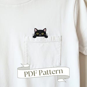 May include: A white t-shirt with a black cat peeking out of a pocket. The text "PDF Pattern" is on a banner below the pocket.