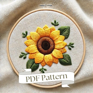 Op de afbeelding: Een PDF-patroon voor borduurwerk met een zonnebloem met groene bladeren in een houten borduurring. De tekst "PDF Pattern" staat op een banner onder de ring.