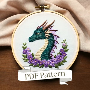 May include: Embroidered dragon design in a hoop, with a teal dragon head and neck, framed by purple flowers and green leaves. The dragon has brown horns and a cream underbelly. The text "PDF Pattern" is on a banner.
