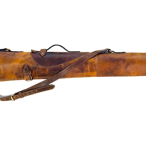 May include: A brown leather gun case with a shoulder strap and buckles. The case is made of distressed leather and has a rustic look.